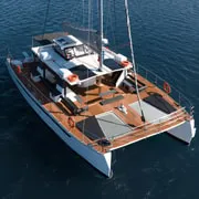 Catamaran deck with served barbecue meal at anchor in the blue caldera during a Santorini boat tour, Greece